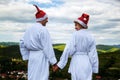 Happy ÃÂouple in a white coat and Santa Helper Hats on the mountain